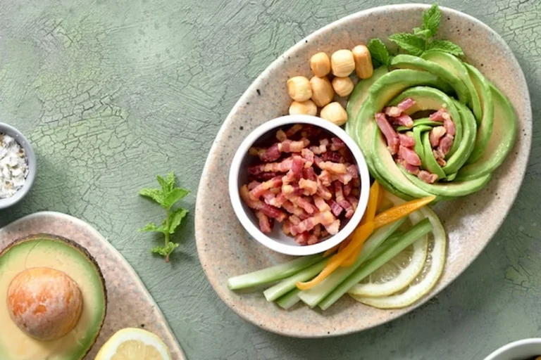 Sałatka różana z awokado, boczkiem i serem na zielonym stole