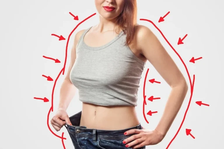 Młoda kobieta w duży dżinsach i szarym topie prezentująca skuteczne odchudzanie