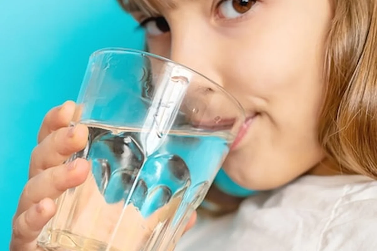 Dziewczynka pije wodę ze szklanki