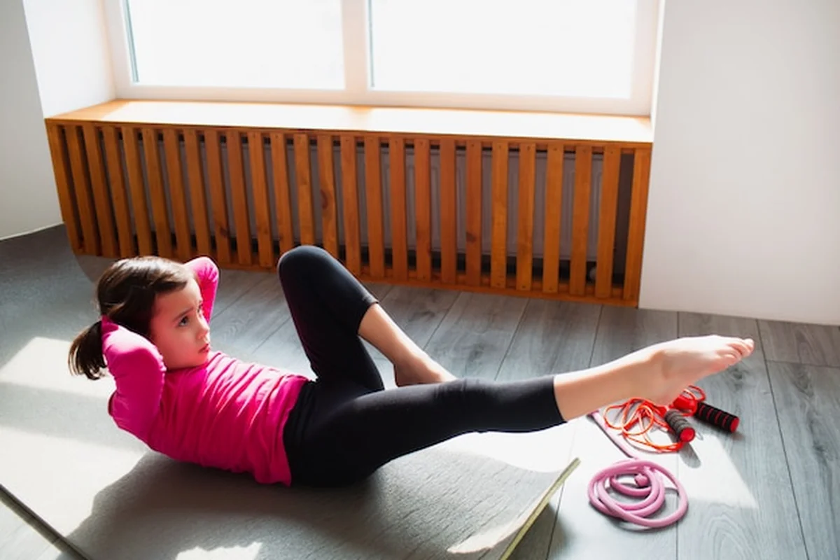 Dziewczynka robi trening ABS w domu