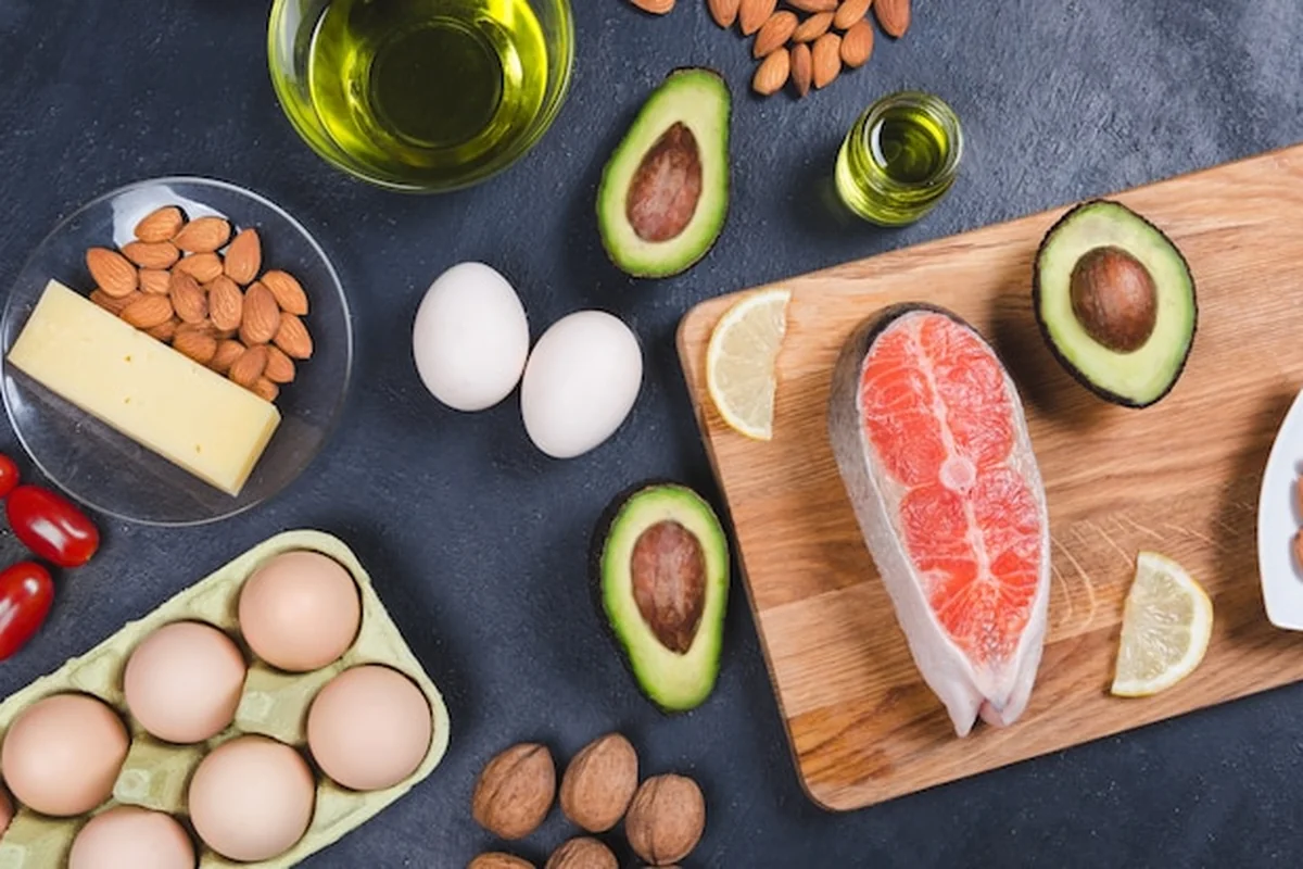 Zdrowa żywność na czarnym tle: awokado, ryby, olej, orzechy