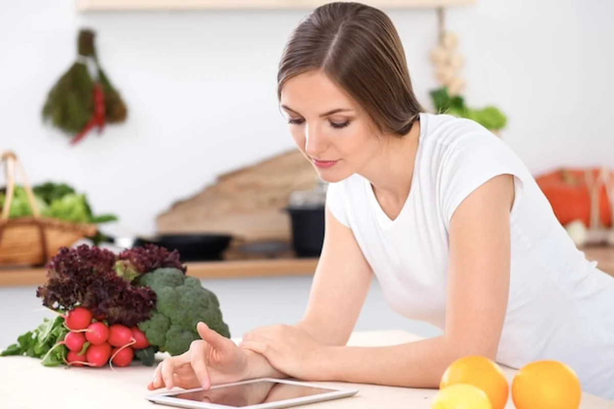 Młoda kobieta robi zakupy online za pomocą tabletu i karty kredytowej