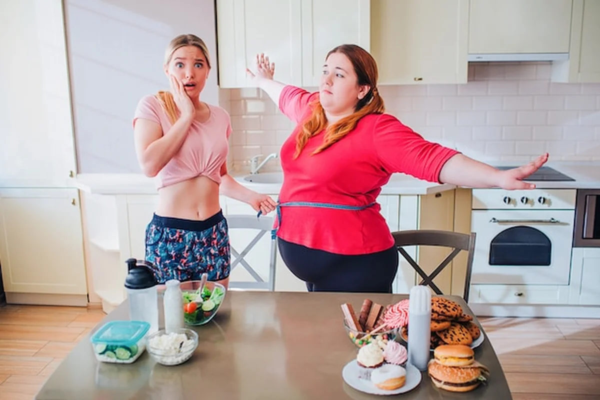 Model plus size stoi obok blondynki i rozkłada ramiona