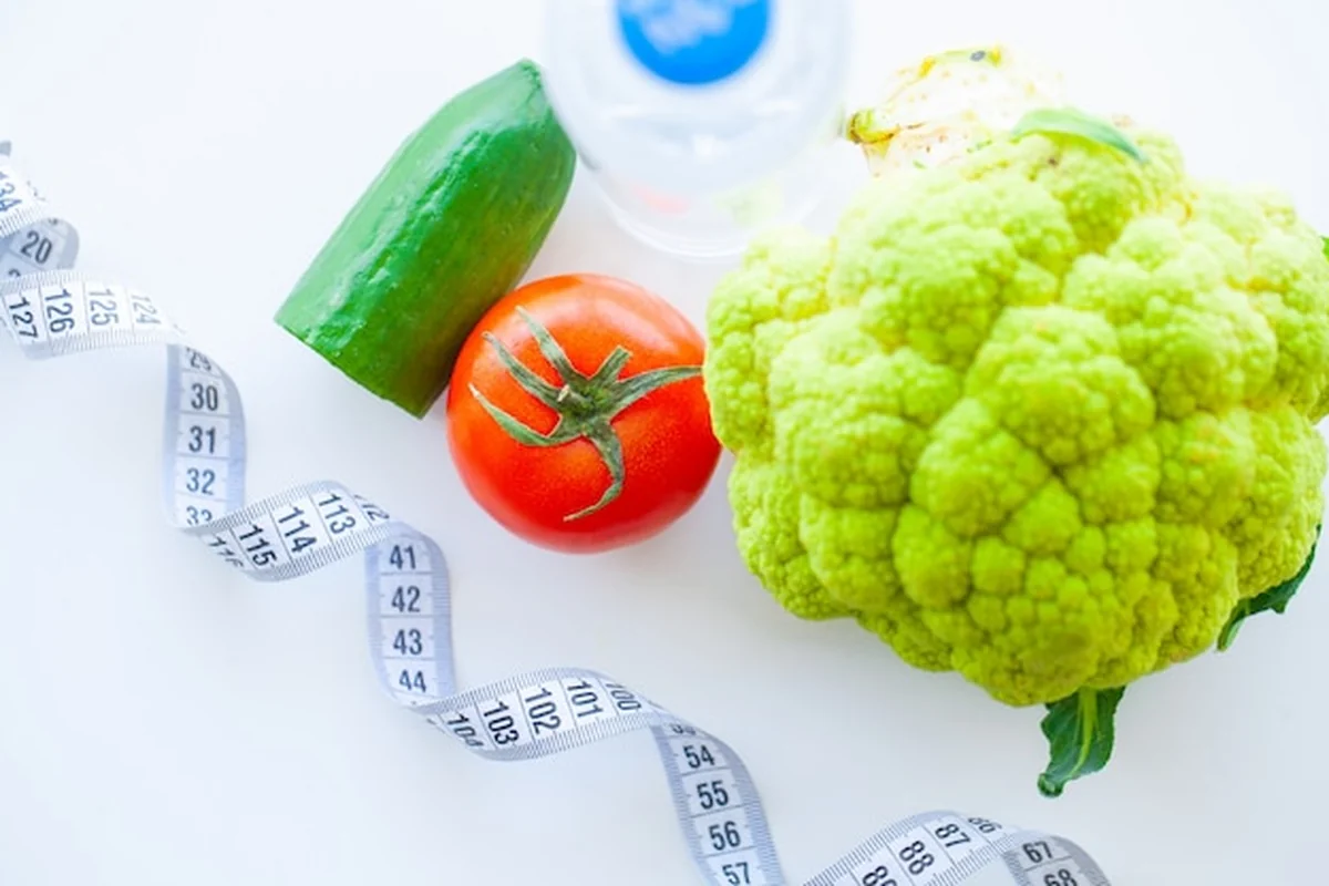 Świeże zielone warzywa na talerzu z taśmą mierniczą