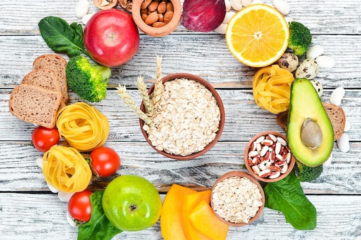 Zdrowa żywność: chleb, makaron, awokado, mąka, dynia, brokuły, fasola, szpinak na białym tle, widok z góry, wolne miejsce