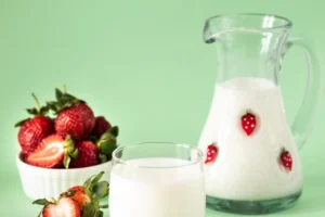 Mleko i truskawki na zielonym tle – zdrowa dieta i styl życia