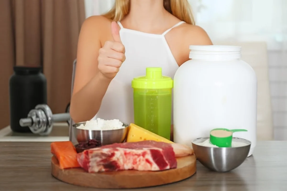 Kobieta przy stole z białkowym shakiem w proszku