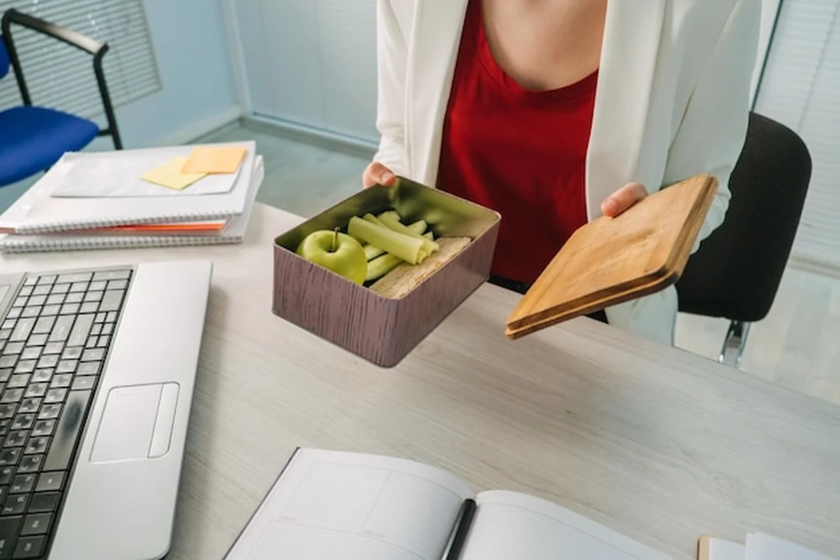 Ręce kobiet trzymające obiad w pudełku z menu diety na utratę wagi